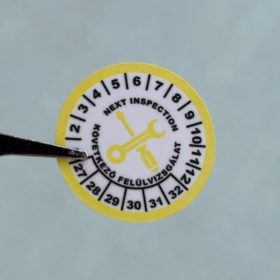   VOID nyomot hagyó 6 éves (2027-2032) felülvizsgálati biztonsági matrica sárga/fekete nyomtatással, 30 mm kör, matt fehér