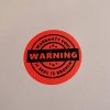"WARRANTY VOID IF SEAL IS BROKEN" Sicherheitspapier-Etikett 35 mm rund, fluoreszierend rot