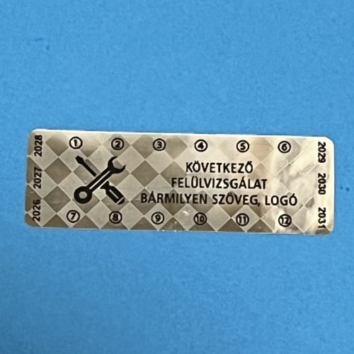 Pepita nyomot hagyó 6 éves (2026-2031) kétnyelvű felülvizsgálati biztonsági matrica 60x20 mm, fényes ezüst