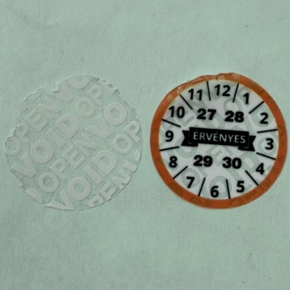 "ÉRVÉNYES" 4 éves (2027-2030) VOID biztonsági matrica 30 mm kör, narancs/fekete nyomtatással, matt fehér