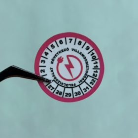   VOID nyomot hagyó 6 éves (2027-2032) villamosbiztonsági felülvizsgálati matrica, piros/fekete nyomtatással, 30 mm kör, matt fehér